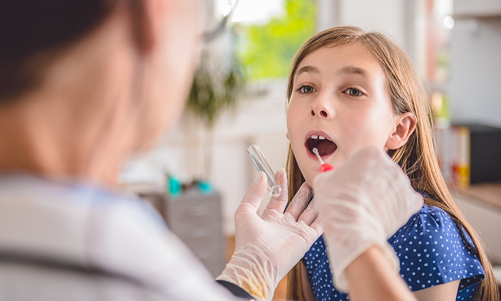 Healthcare professional collecting a throat swab from a child.